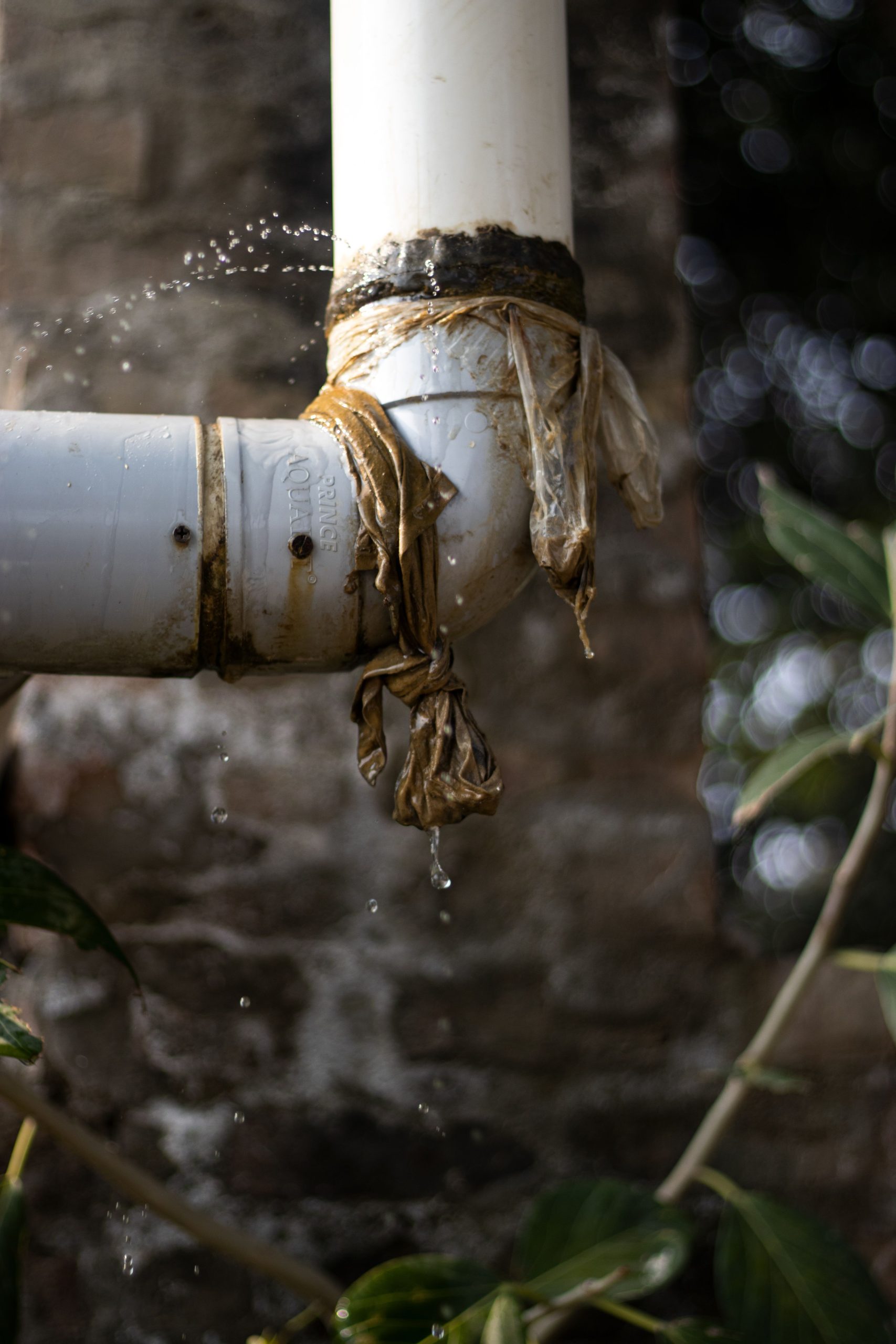 Persona revisando una fuga de agua en cañería de cocina